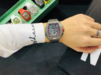 Richard Mille watch on wrist with black rubber strap and silver-toned skeleton case