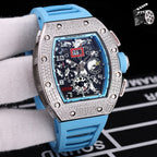 Wristwatch with silver case, blue silicone strap, skeleton dial with visible gears