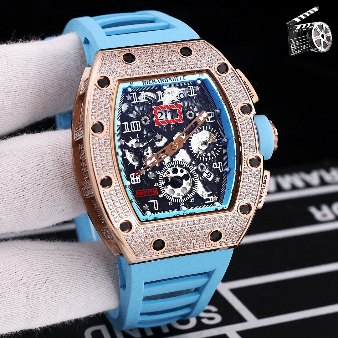 Rose gold diamond bezel wristwatch with blue silicone strap and skeleton dial.