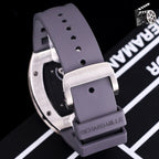 Richard Mille watch with purple rubber strap and buckle, stainless case edge visible.