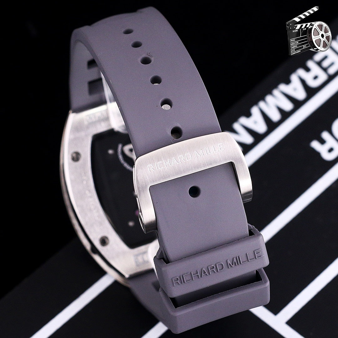 Richard Mille watch with purple rubber strap and buckle, stainless case edge visible.