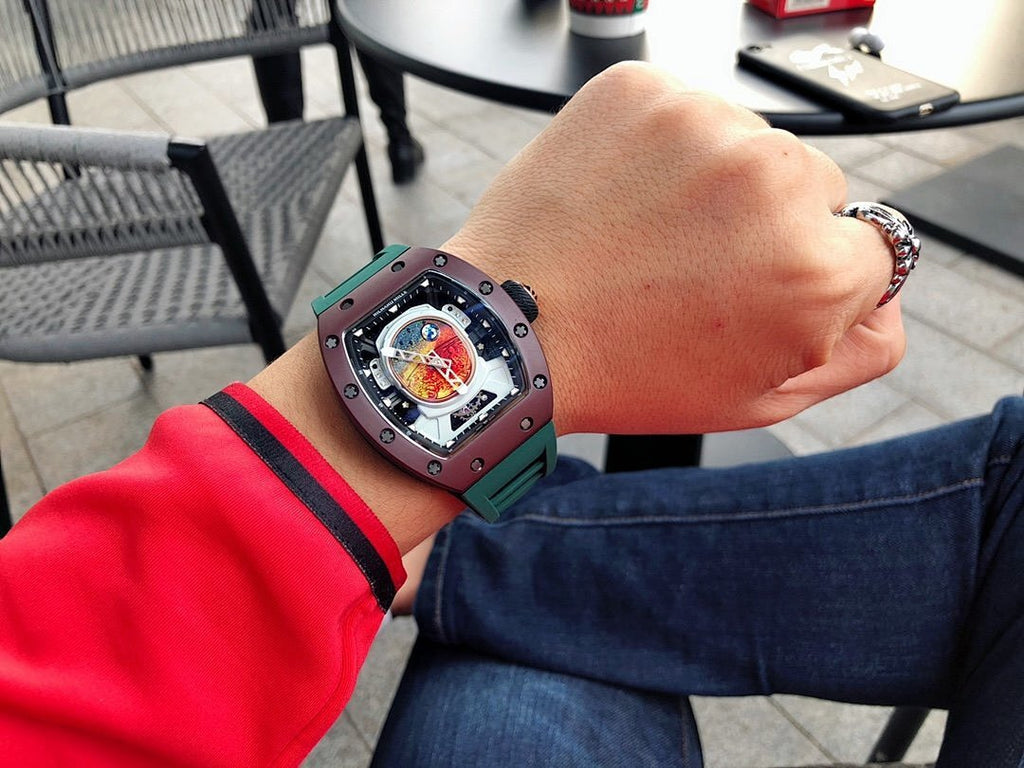 Richard Mille watch with green strap on wrist, dark square case, skeleton dial view