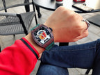 Richard Mille watch with green strap on wrist, dark square case, skeleton dial view