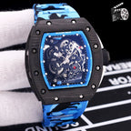 Blue camo rubber strap watch with black case and skeleton dial, visible mechanical gears.