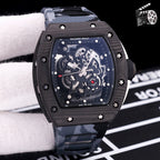 Dark skeleton dial watch with black case and gray camouflage rubber strap.