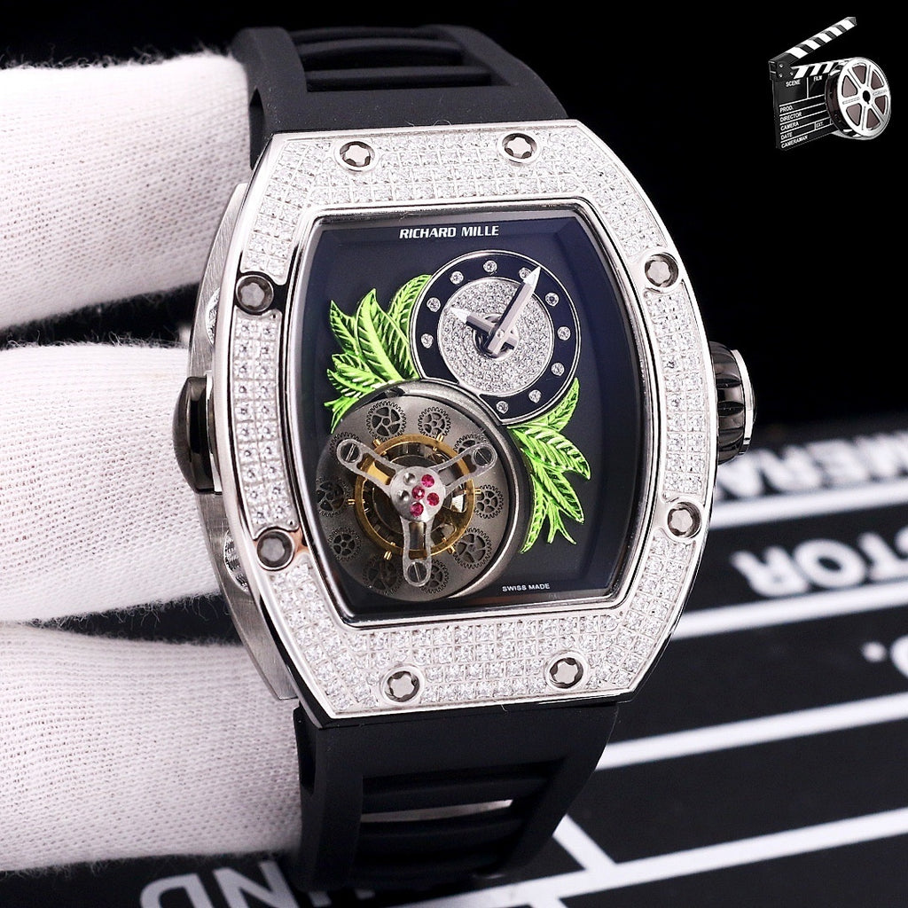 Silver-toned watch with black silicone strap; dark dial with green leaf art and skeleton movement.