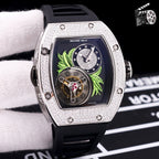 Silver-toned watch with black silicone strap; dark dial with green leaf art and skeleton movement.