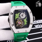 Silver-toned watch with green silicone strap; dark dial with green leaf art and skeleton movement.