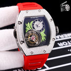 Silver-toned watch with red silicone strap; dark dial with green leaf art and skeleton movement.