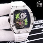 Silver-toned watch with white silicone strap; dark dial, green leaf motif, and jeweled bezel.