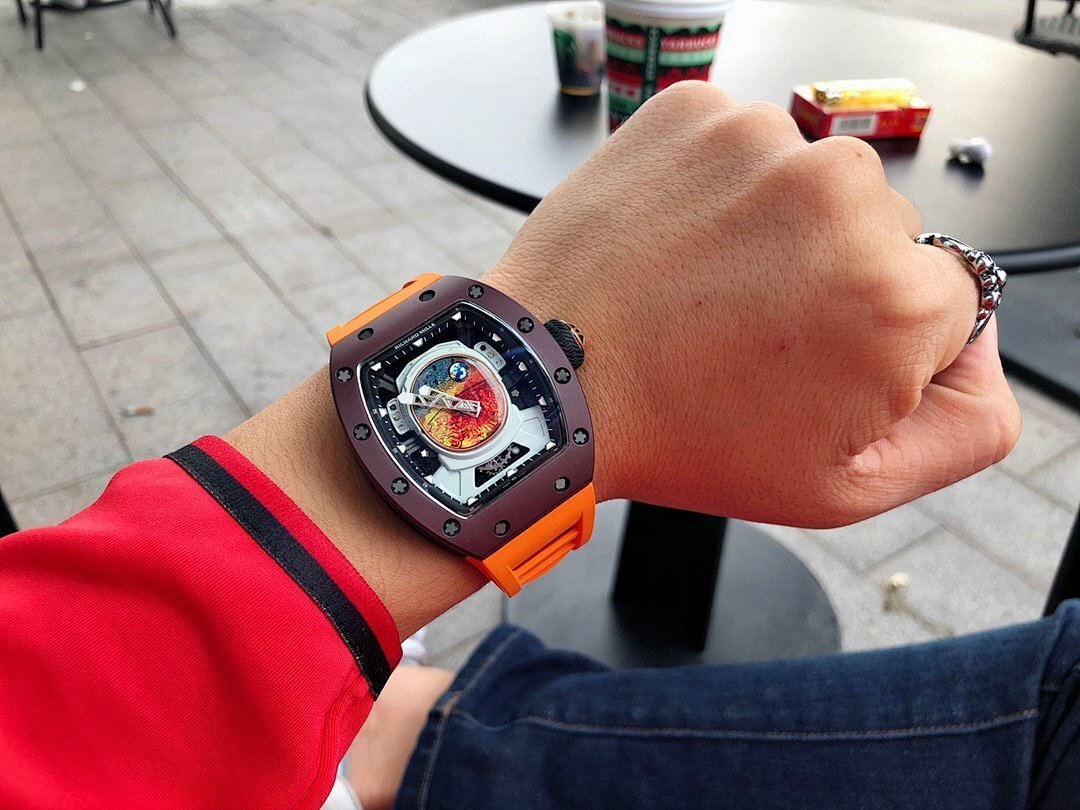 Richard Mille watch on wrist with dark brown case and orange rubber strap