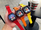Richard Mille watch with dark brown case and red, orange, and yellow rubber straps held in hand