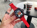 Richard Mille watch with dark brown case and red rubber strap, colorful dial visible in hand