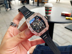 Richard Mille watch with jeweled bezel, dark skeleton dial, black strap on hand.