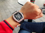 Richard Mille watch on wrist with jeweled bezel and black strap, clear skeleton dial.