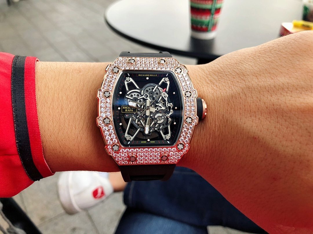 Richard Mille watch with jeweled bezel, black skeleton dial, black strap on forearm.