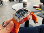 Richard Mille watch with jeweled bezel, skeleton dial, bright orange strap and crown.