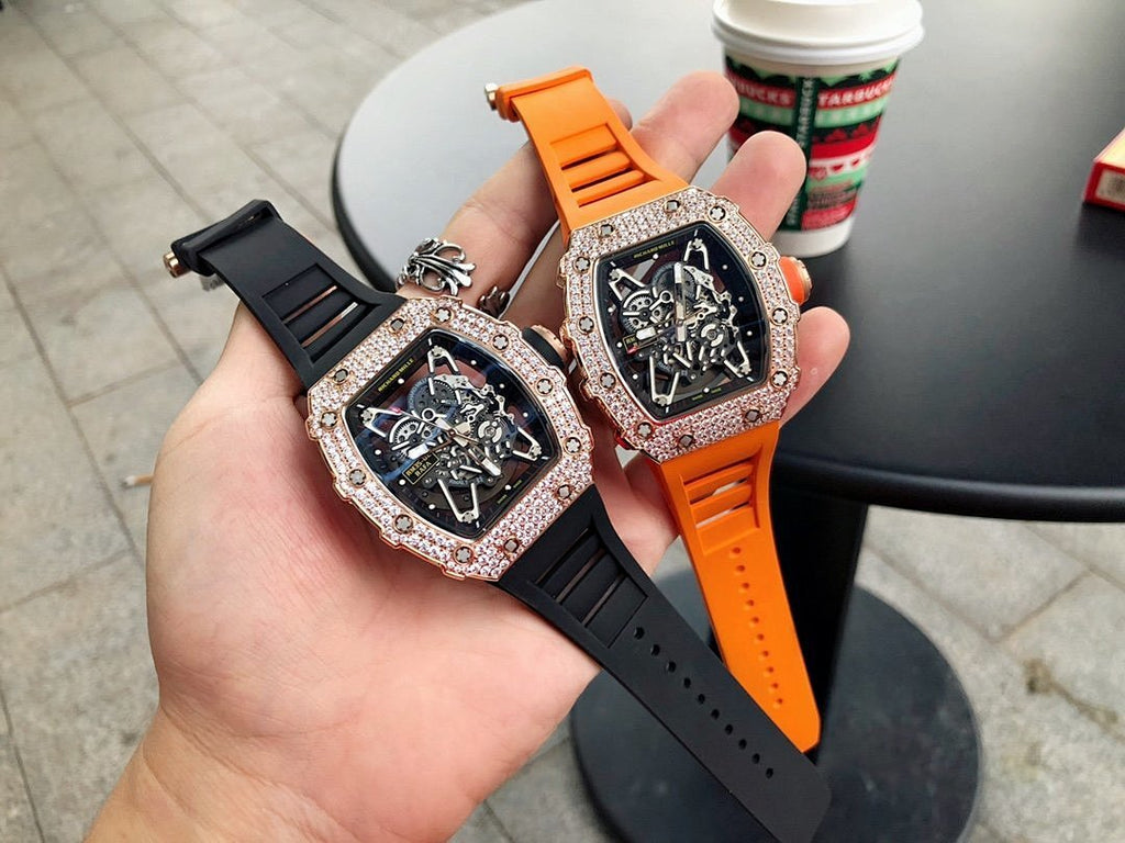 Richard Mille watch with jeweled bezel, black dial, orange and black strap, wrist-ready.