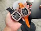 Richard Mille watch with jeweled bezel, black dial, orange and black strap, wrist-ready.