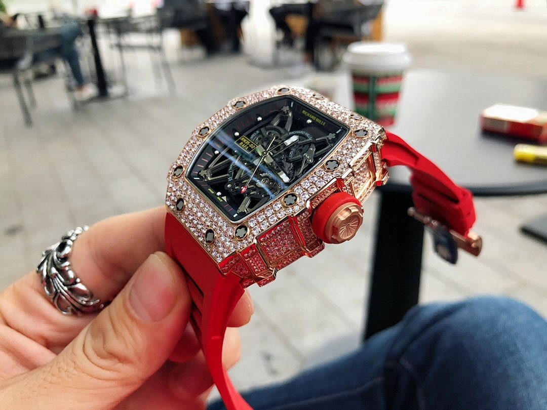 Men’s jeweled skeleton watch with red silicone strap angled view, black dial