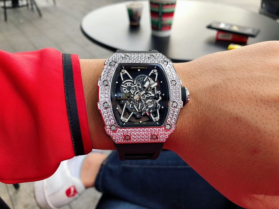 Richard Mille watch on wrist with dark strap and jeweled silver bezel