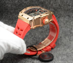 Richard Mille watch with red strap, rose-gold tone case side and protective links.