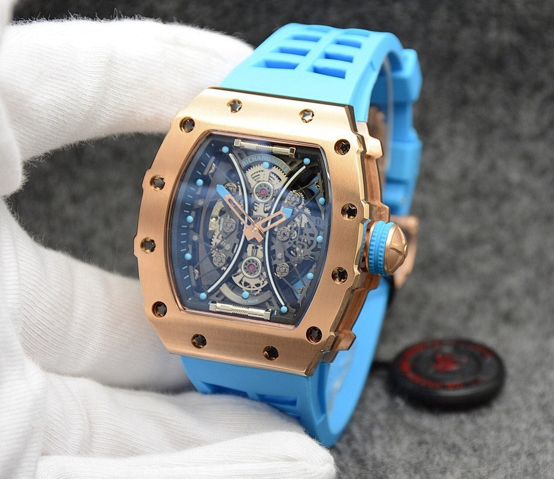 Richard Mille watch with blue silicone strap, gold-toned case, skeleton dial face.