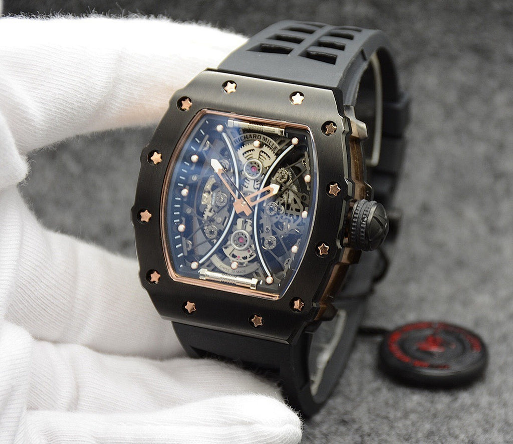 Richard Mille watch with black silicone strap, gold-trim case, skeleton dial detail.