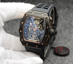 Richard Mille watch with black silicone strap, gold-trim case, skeleton dial detail.