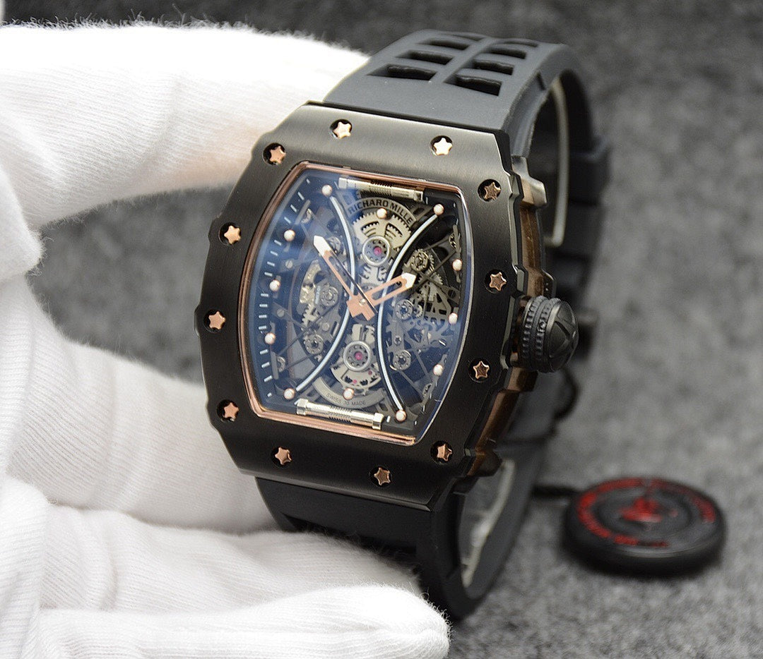 Richard Mille watch with black silicone strap, gold-trim case, skeleton dial detail.