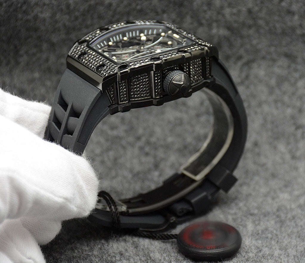 Richard Mille watch with black case bezel and raised crown, black rubber strap