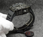 Richard Mille watch with black case bezel and raised crown, black rubber strap