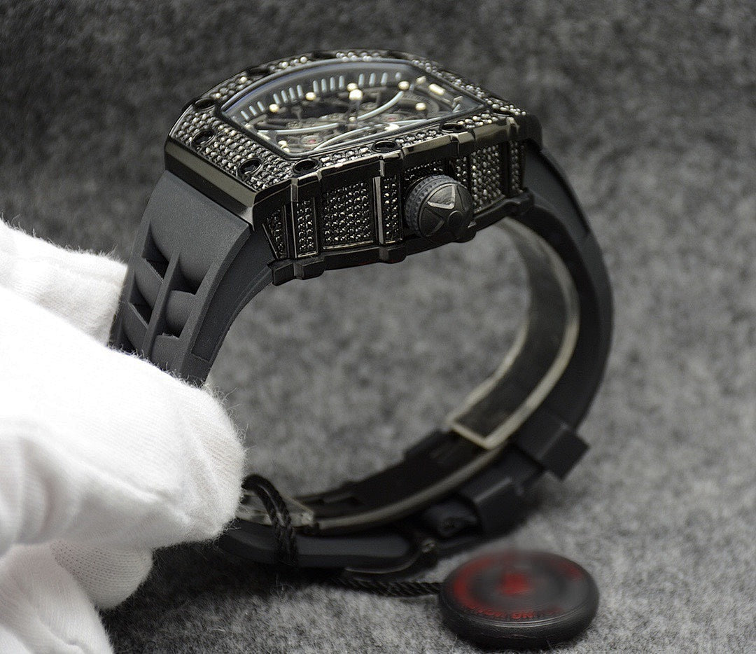 Richard Mille watch with black case bezel and raised crown, black rubber strap