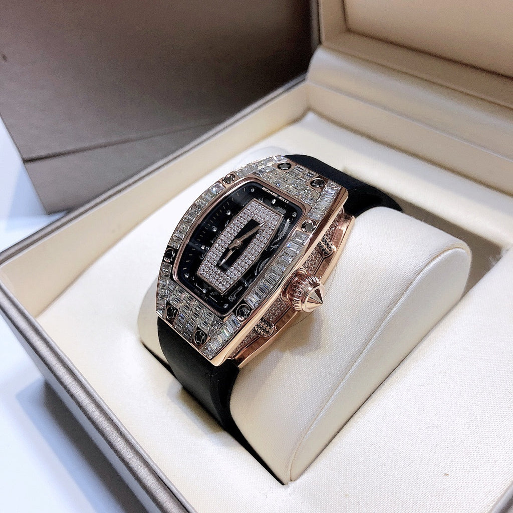 Richard Mille watch displayed on pillow with black rubber strap and rose-gold case