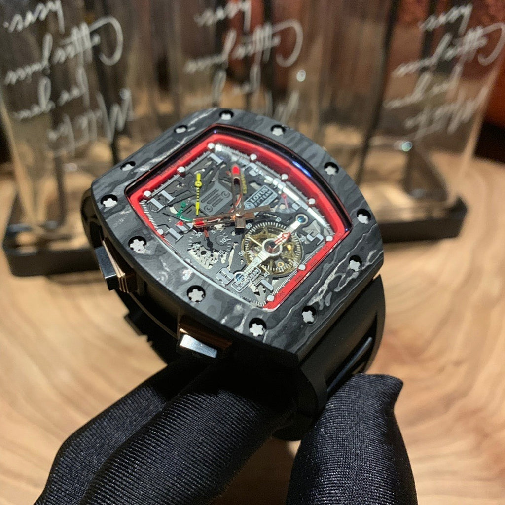 Richard Mille watch front view, red bezel outline, multi-color skeleton dial, black strap