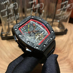 Richard Mille watch front view, red bezel outline, multi-color skeleton dial, black strap