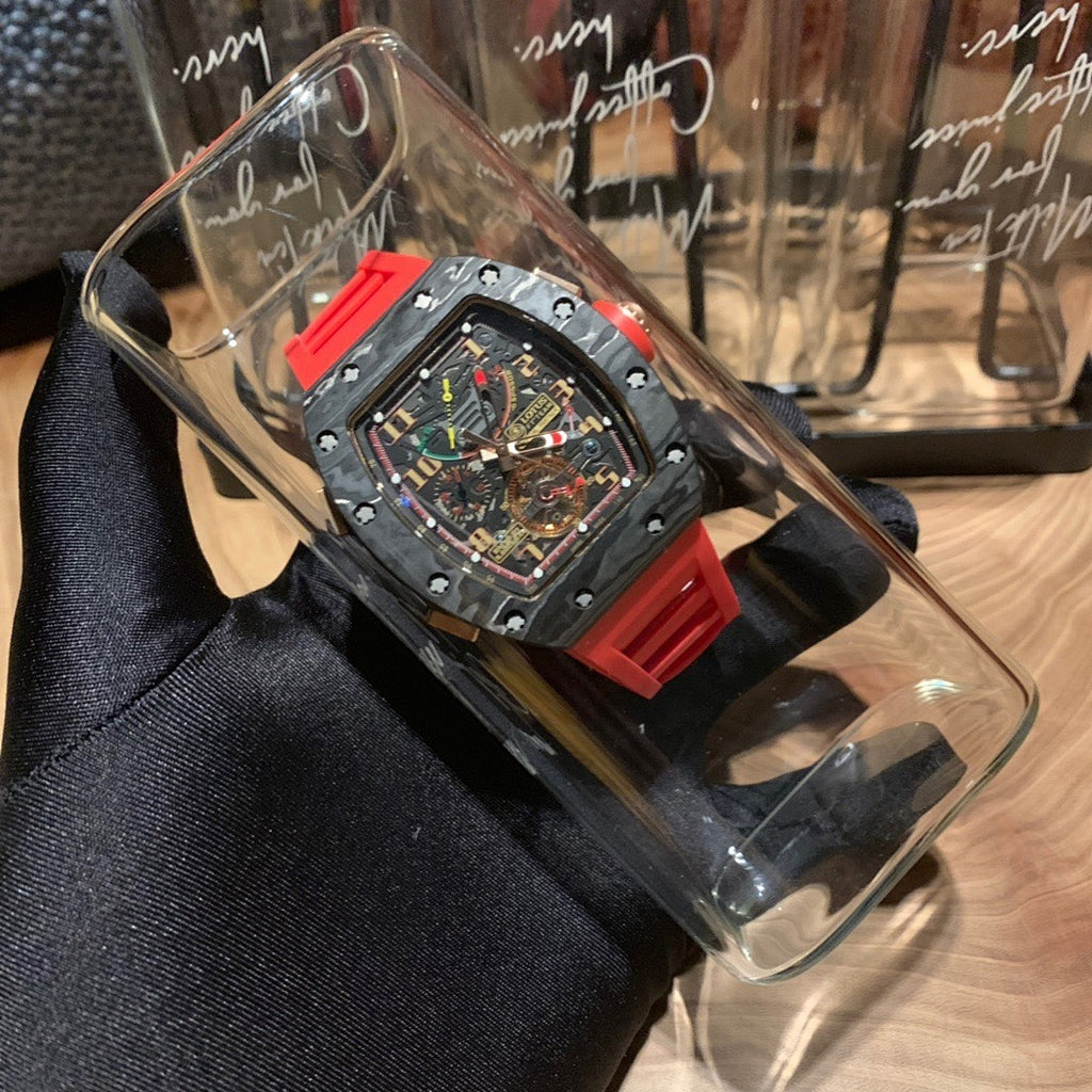 Richard Mille watch in clear box, black dial with visible mechanics and red strap
