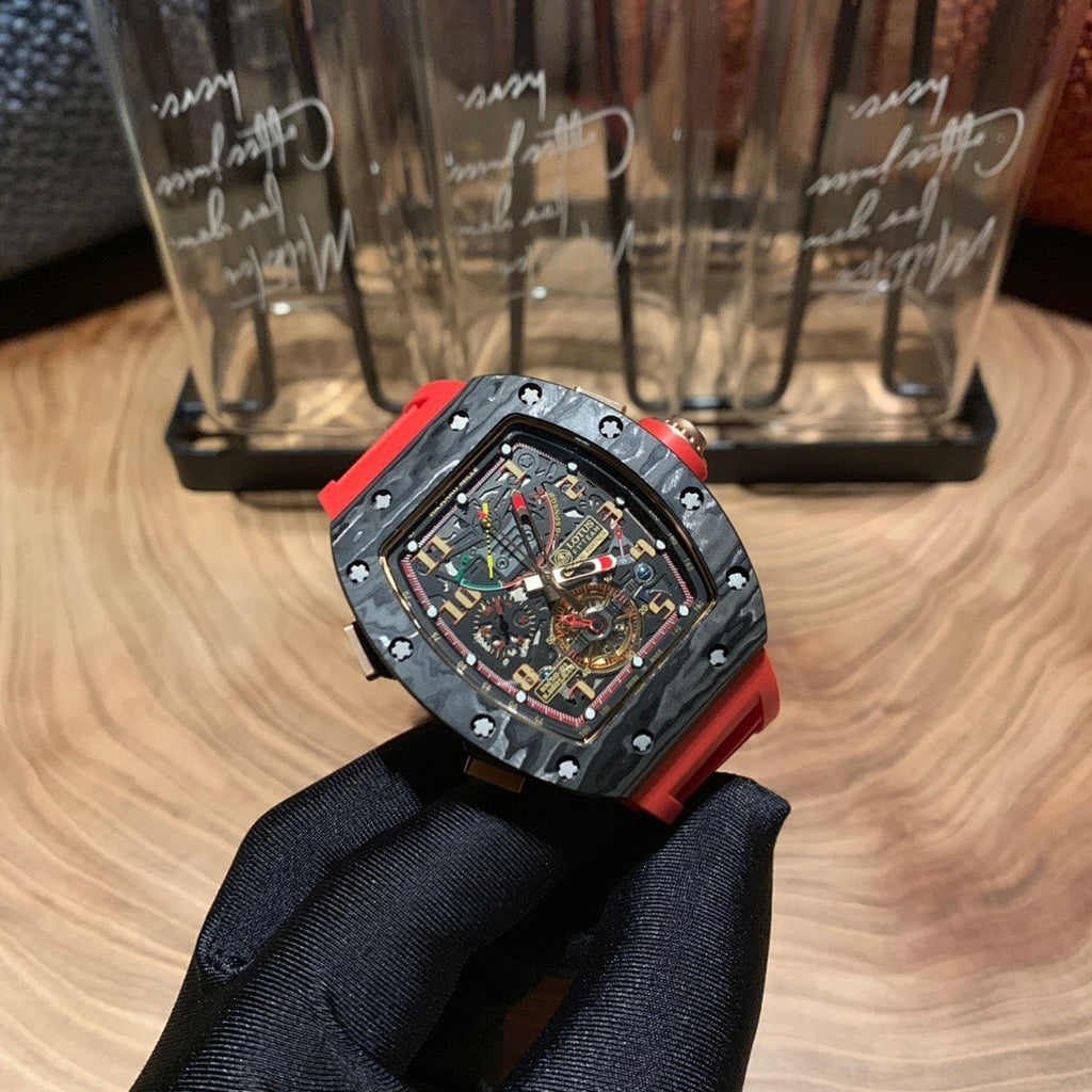 Richard Mille watch front view, black skeleton dial with multicolor hands and red strap