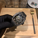 Skeleton watch face with exposed movement, octagonal black case and blue interior