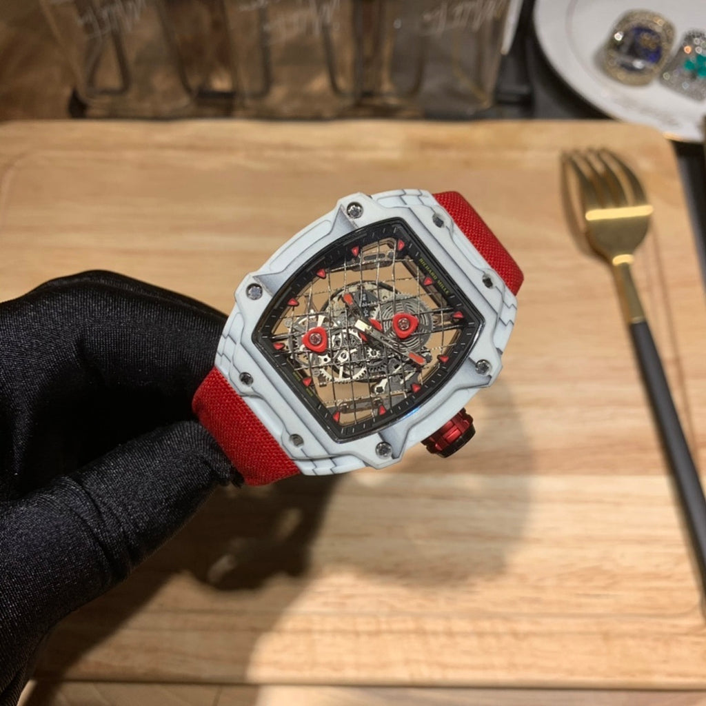 Square luxury watch with red strap and white case, mechanical dial under clear glass.