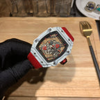 Square luxury watch with red strap and white case, mechanical dial under clear glass.