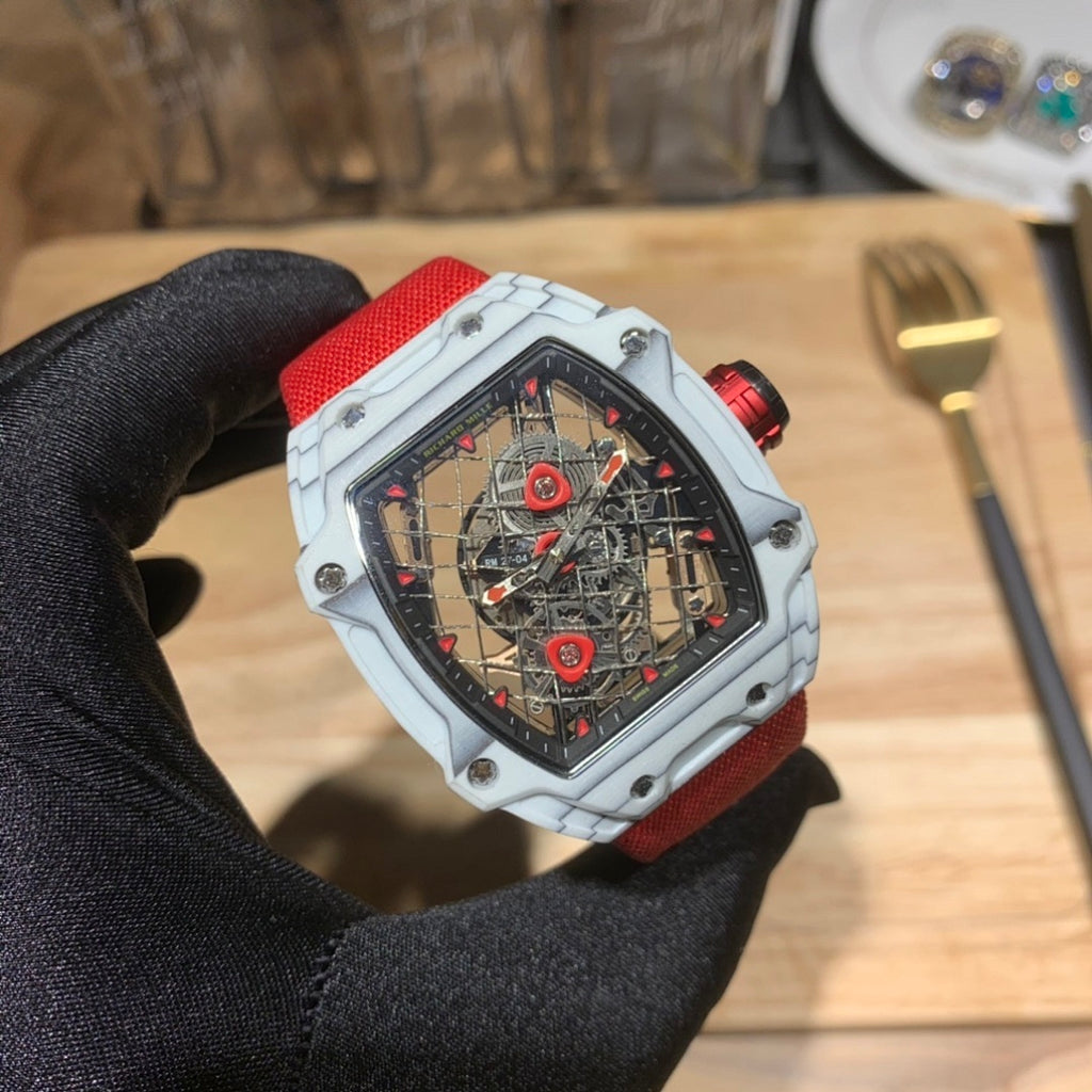 Square luxury skeleton watch, white case and red strap, red-toned movement details.