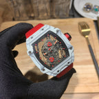 Square luxury skeleton watch, white case and red strap, red-toned movement details.