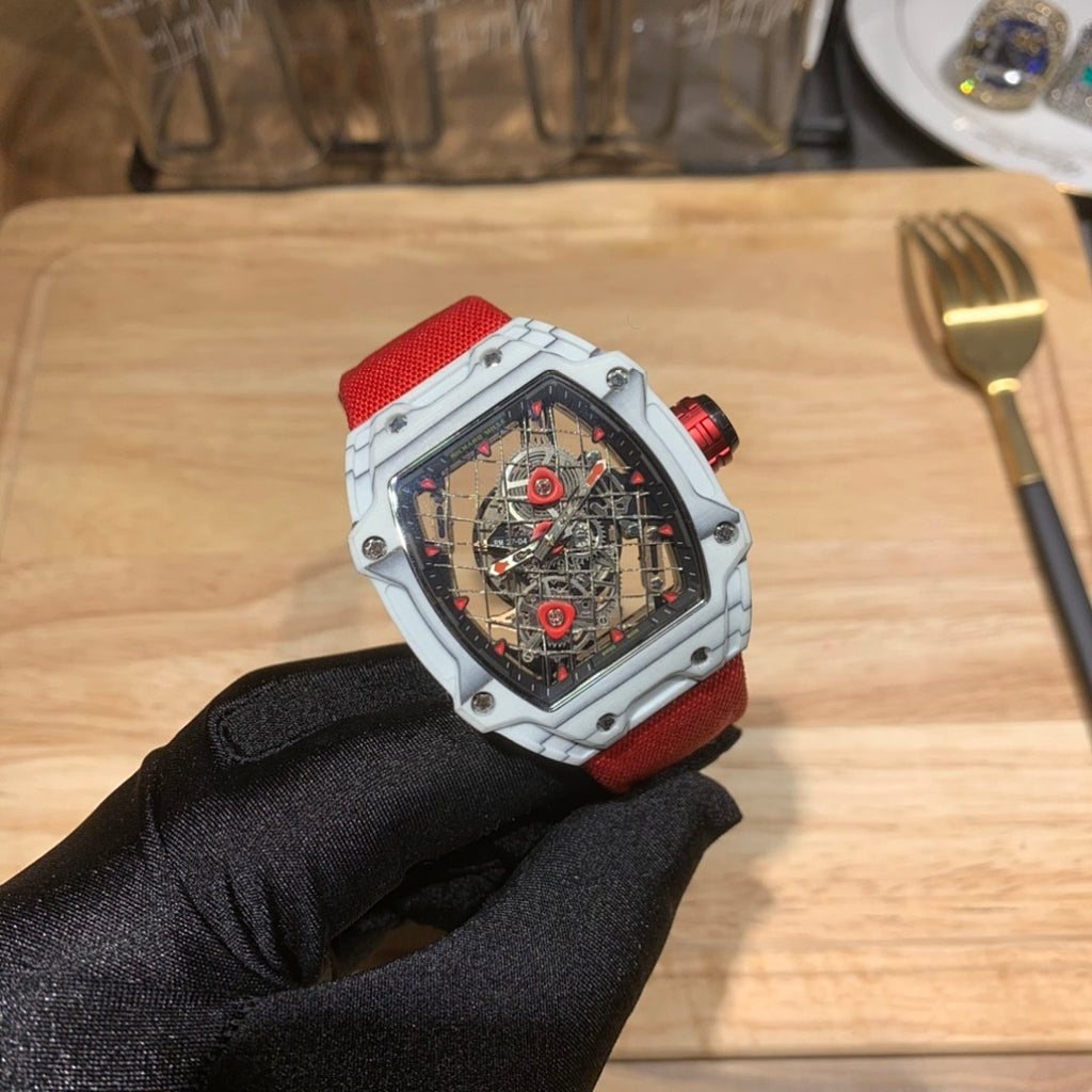 Square luxury skeleton watch on red strap, white case with visible mechanical movement.