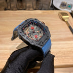 Richard Mille watch with blue fabric strap and dark case, skeleton dial facing left