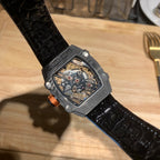 Richard Mille watch with black textured strap and dark square case; skeleton dial