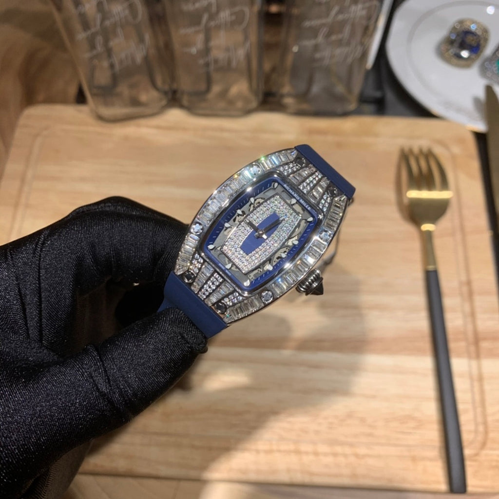 Richard Mille watch with blue strap and silver jeweled bezel, front view on glove