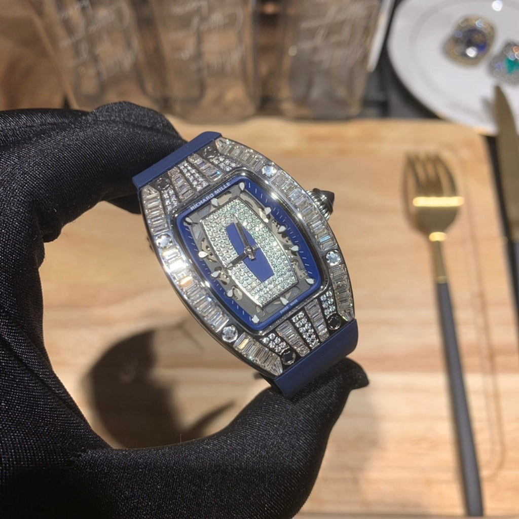 Richard Mille watch close-up on blue strap with silver jeweled frame, on gloved hand