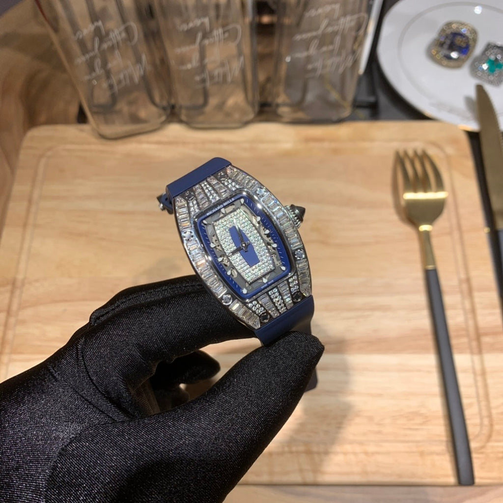 Richard Mille watch with blue strap and silver jeweled case, angled on gloved hand