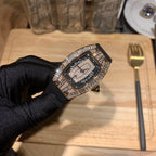 Black dial luxury watch with diamond-studded case and black strap, angled view